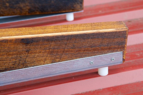 Detail of the top end of the sled, showing the wood, metal rail and nylon spacer.
