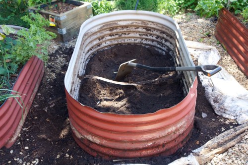 The first step is to dig out the existing garden beds.