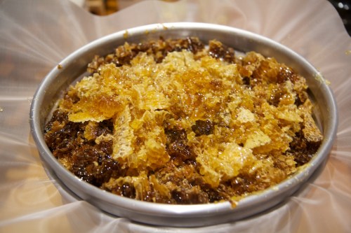 Breaking up the honeycomb, letting the honey drain out.